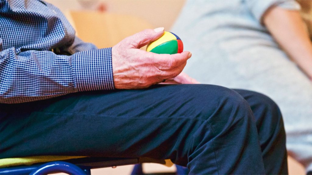 Therapeutin unterstützt eine Patientin bei einer Übung mit dem Theraband in der Praxis für Ergotherapie Enver Herrmann